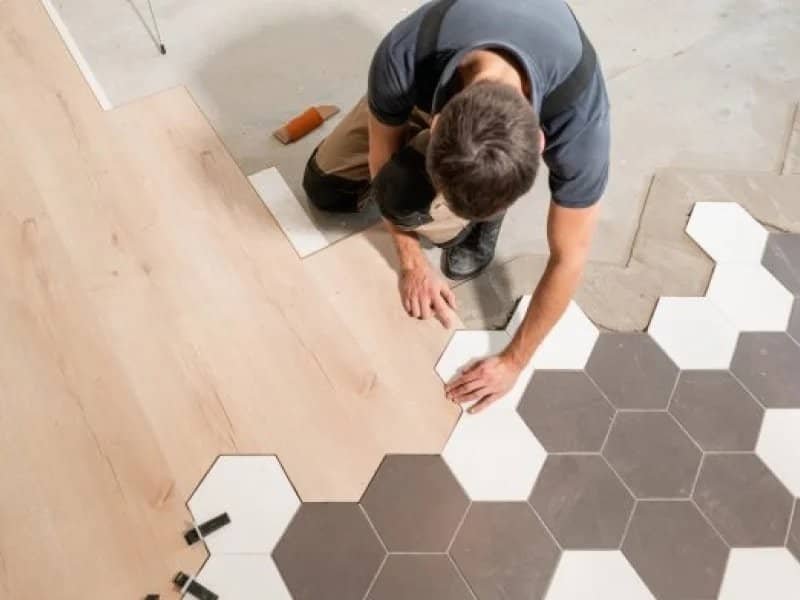 flooring installer combining ceramic and wood flooring in a modern pattern